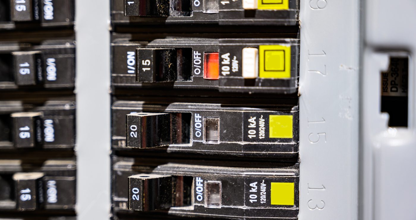 Close-up of breakers in a main electrical panel, where whole-home surge protection is installed.