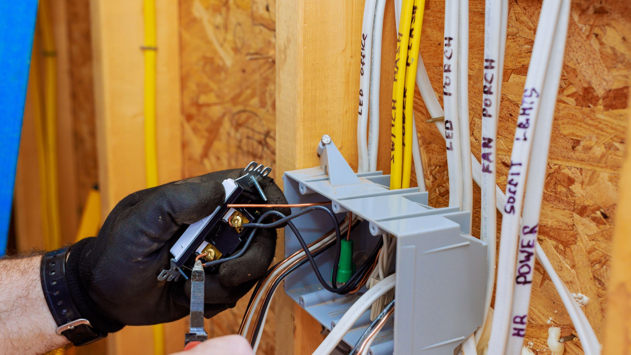 Electrical rough-in wiring being run into a box in new-construction framing on a North Central Iowa job.