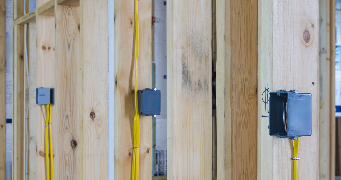 New-construction electrical rough-in with boxes and wiring run through wall framing.