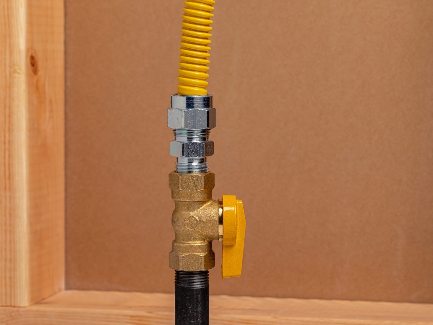 Residential gas shutoff valve and flexible connector, representative of gas line installation and service.