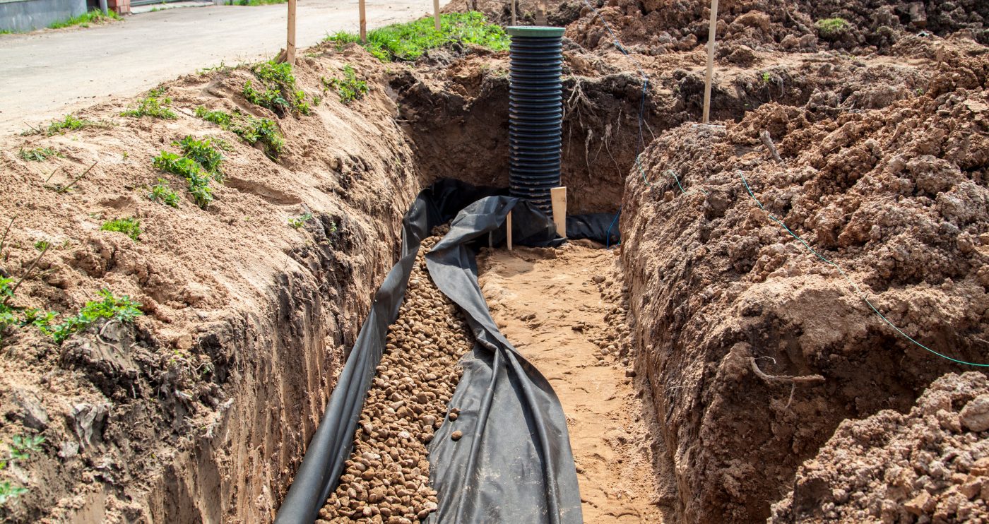 Excavated trench with ground-loop piping for a geothermal heating and cooling system.