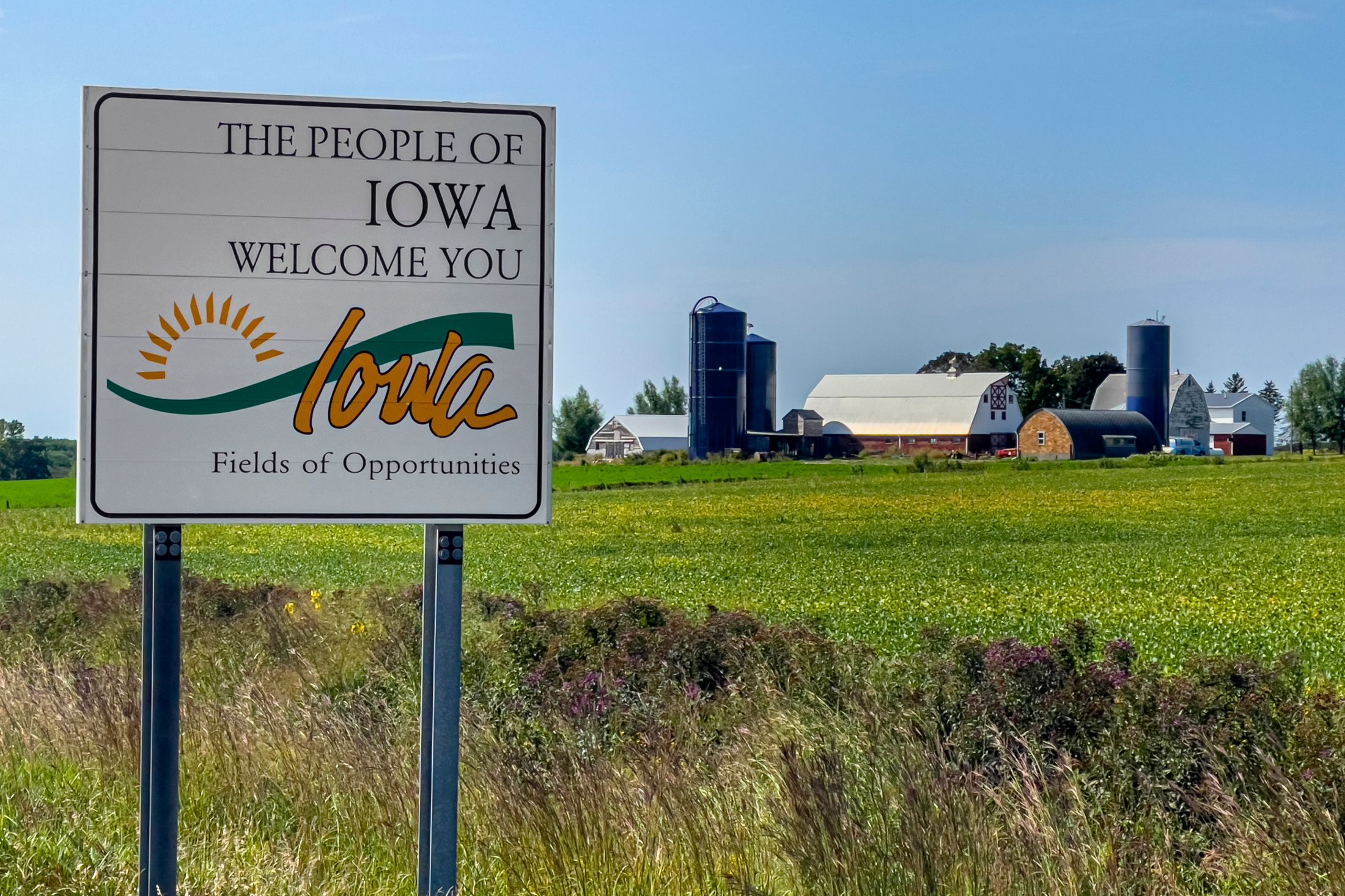 Iowa welcome sign along a rural highway into the Algona area.