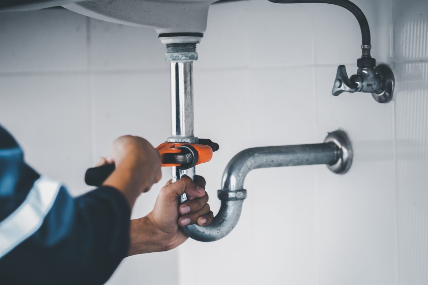 Plumber replacing a sink P-trap during a residential plumbing repair, representative of NCIS plumbing services.