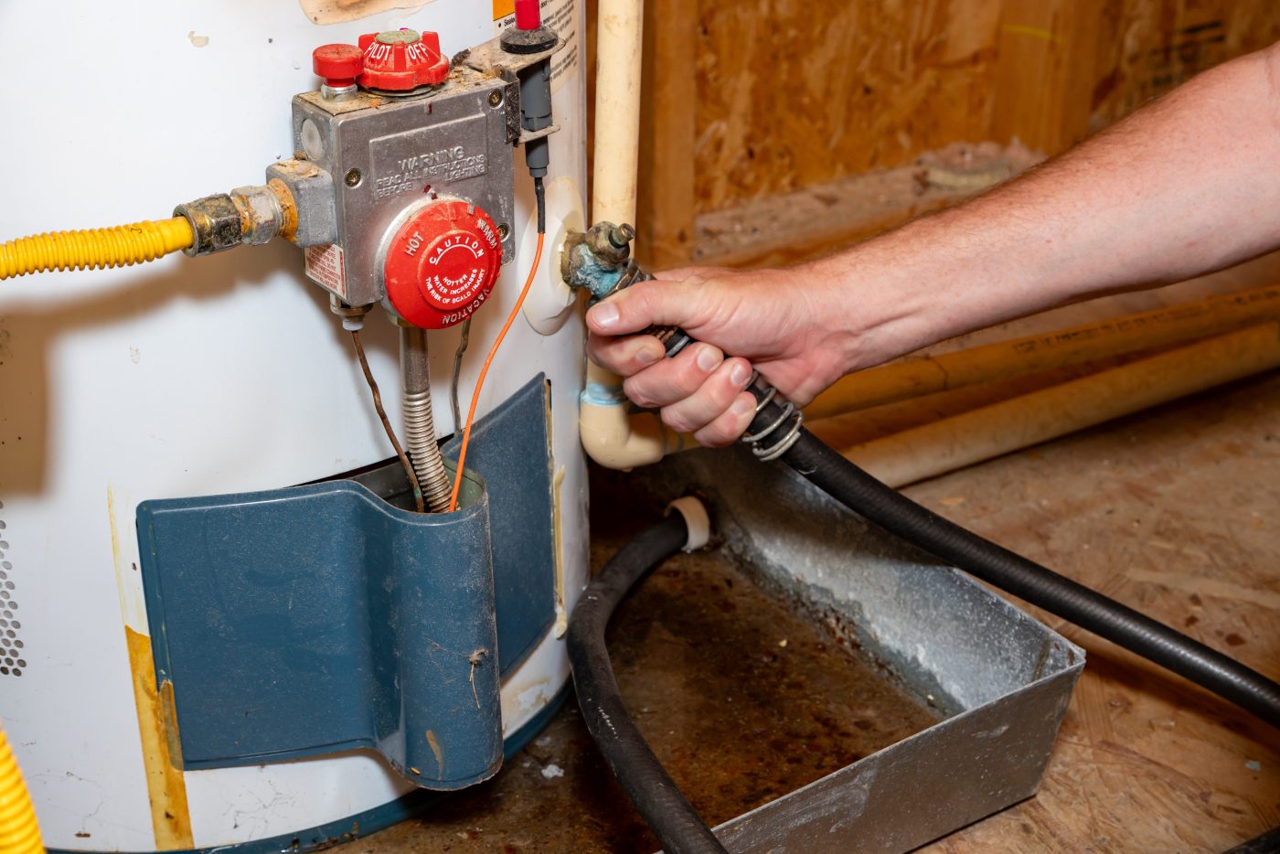 NCIS plumber draining a failed water heater on an emergency service call in North Central Iowa.